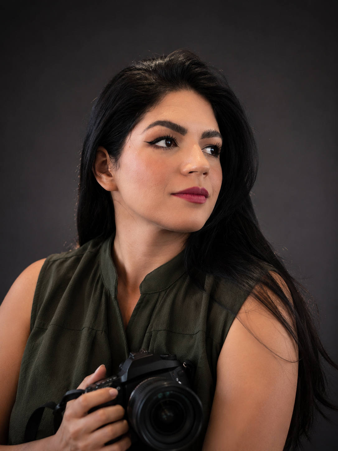 Sandra Moreira, fotógrafa profissional, segurando sua câmera