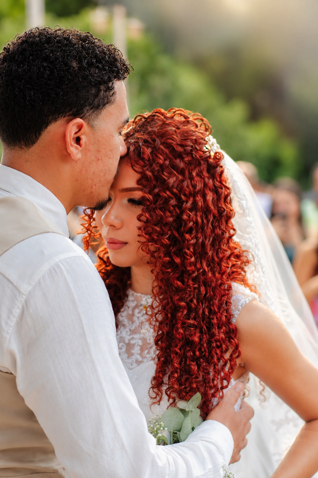 Casal de noivos abraçados durante cerimônia de casamento
